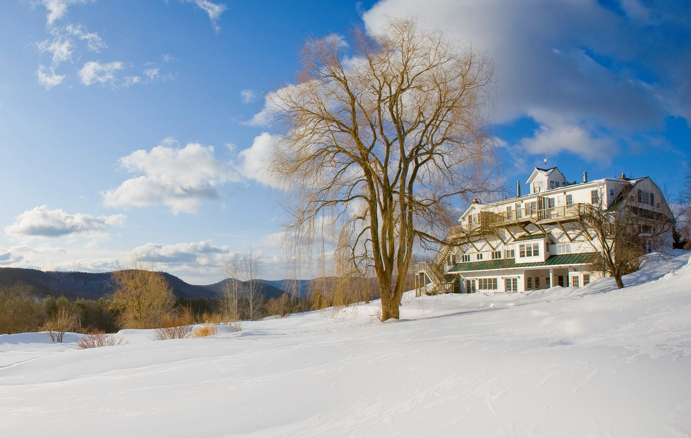 Landscape shot of windham hill inn with snow covered field in the foreground